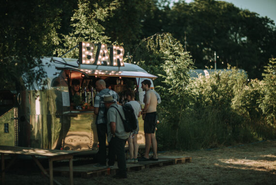 Four people stand outside a bar.