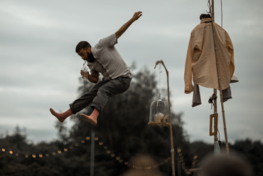 A man jumps in mid air holding a cup.